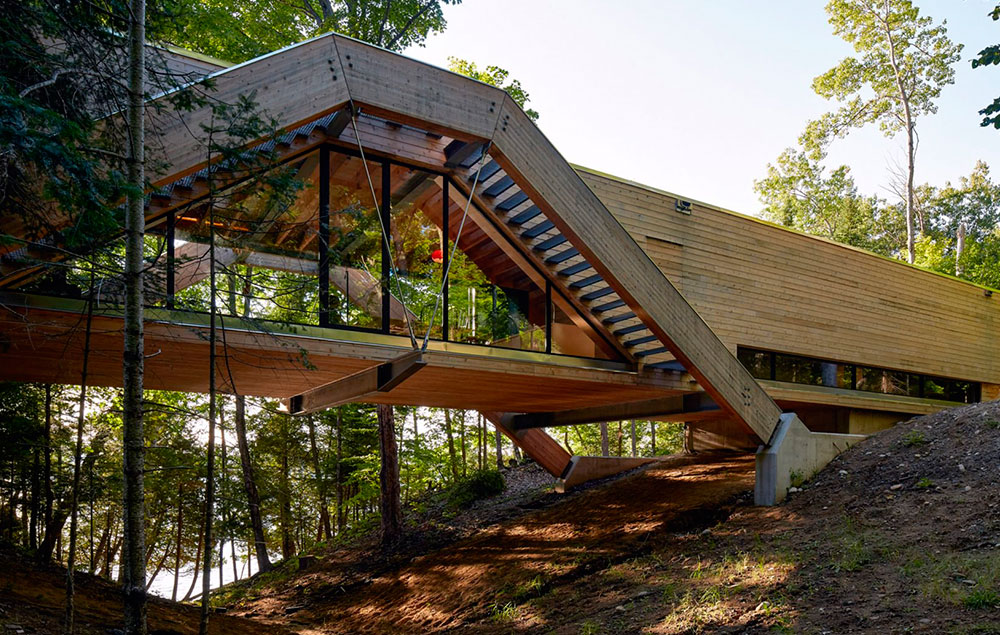 Una casa de madera se extiende como un puente en un bosque canadiense
